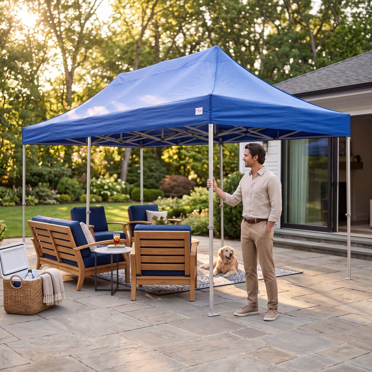Army Stores blue heavy duty pop up canopy shelter set up on a stone patio with a man and a dog nearby